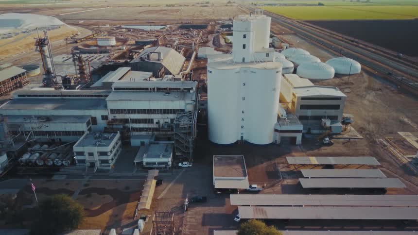 Industrial complex with storage silos and rail lines in an agricultural area