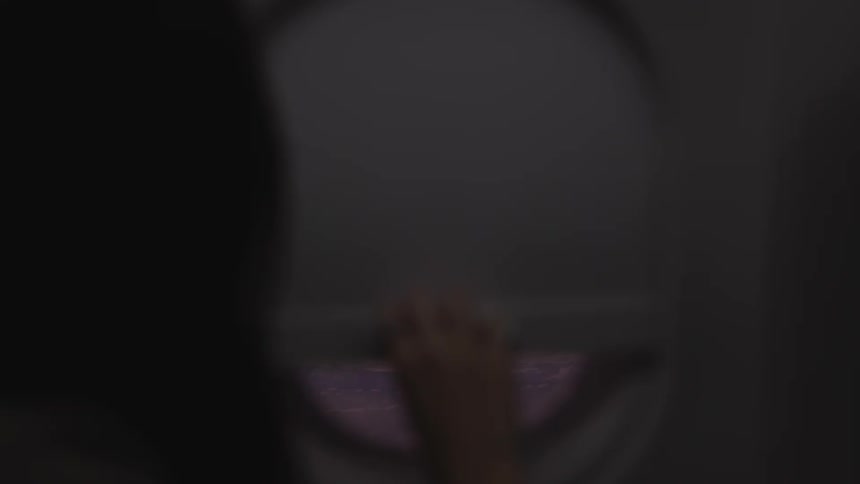 A person closing a window on a plane