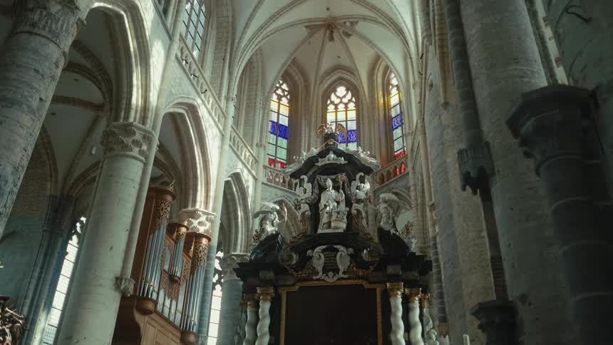 A grand cathedral with soaring vaulted ceilings adorned with intricate patterns beams of light filtering through stained glass windows in shades of blue and red and a stunning altar surrounded by detailed sculptures