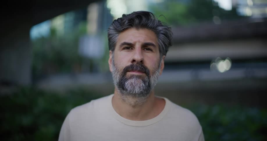 Bearded man wearing a white shirt standing outdoors during day time