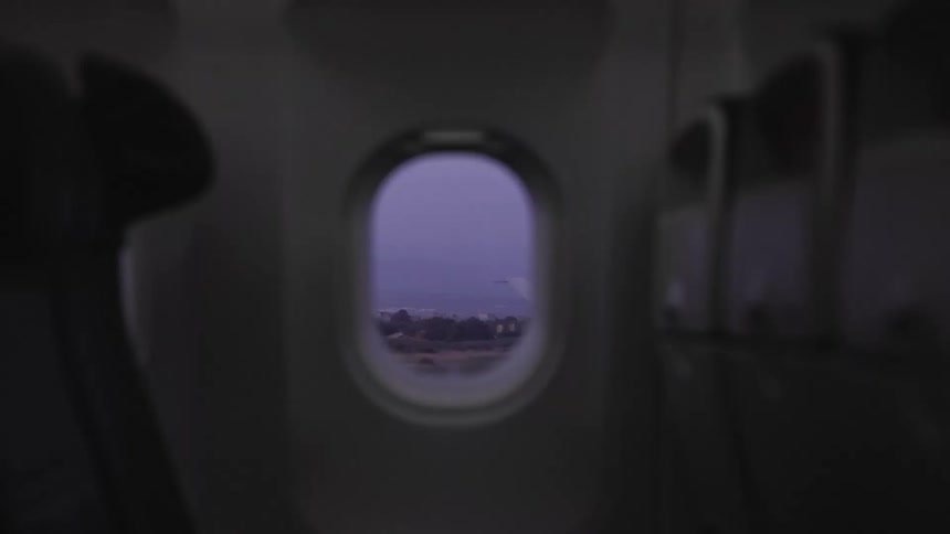 Airplane lights going out with a view of an interior window