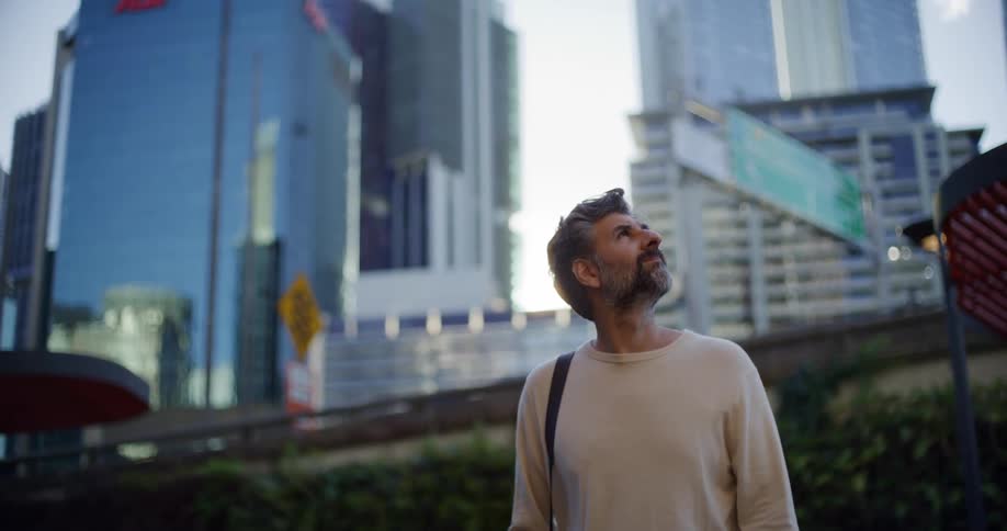 Man looking around at the buildings of a city