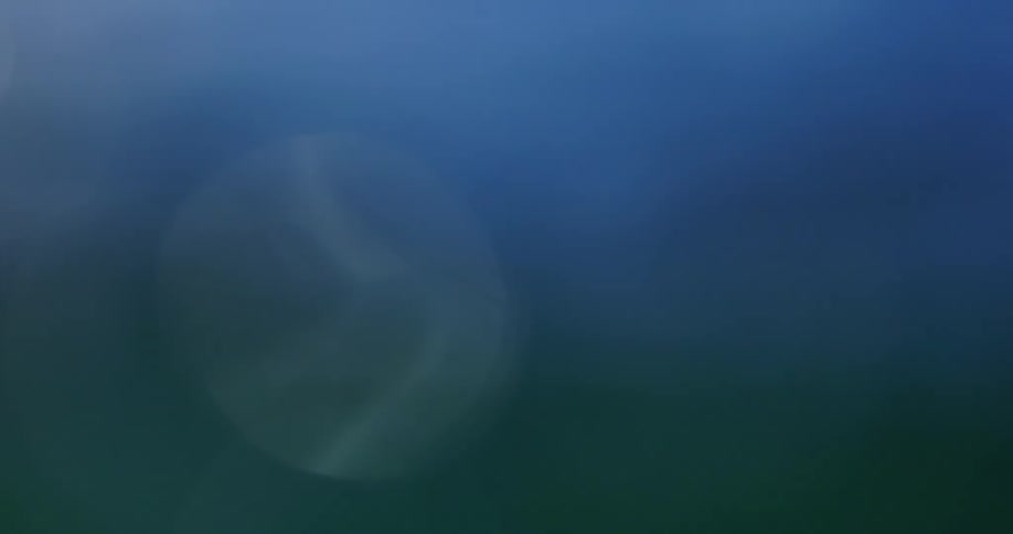 Blurry close up of the surface of a flowing body of water outdoors during daytime