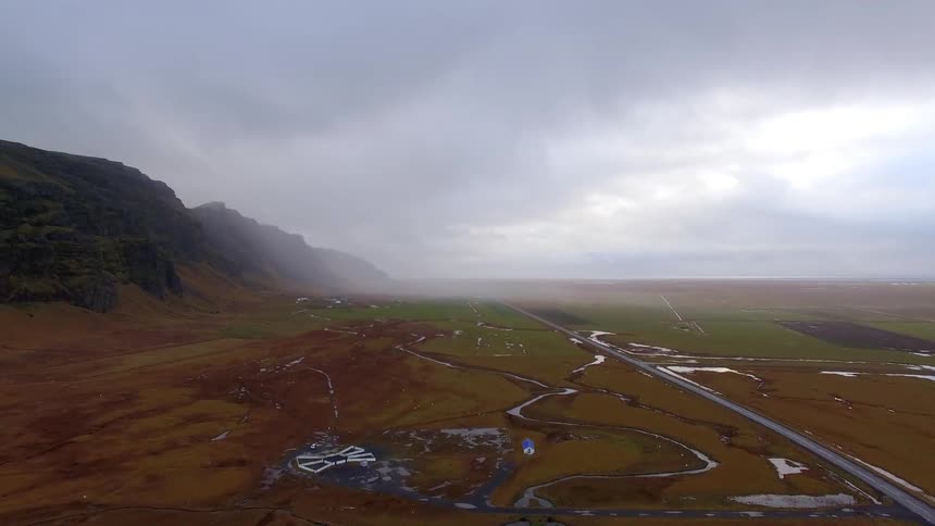 The long field is lined with tall mountains
