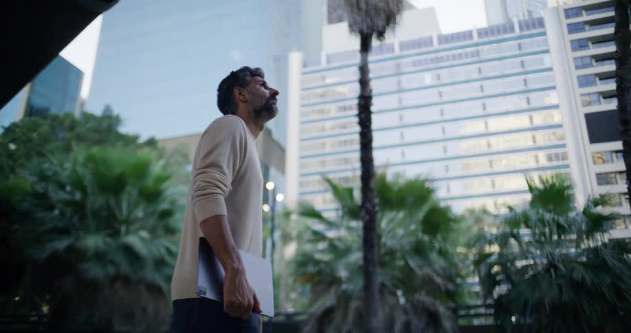 Man with an ipad observing buildings around him