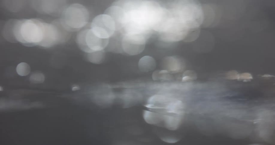 Calm water with bubbles and reflection of the sun