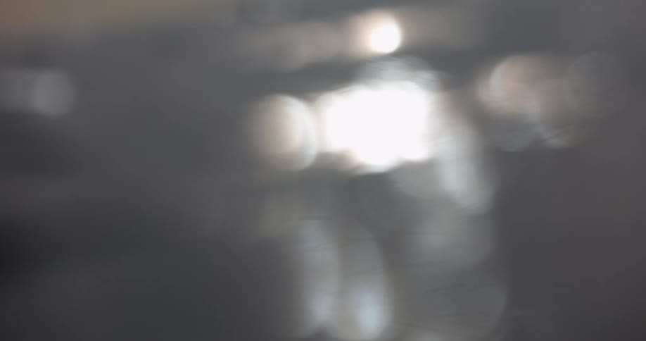 Water surface in closeup shows gentle ripples with diffused light reflections