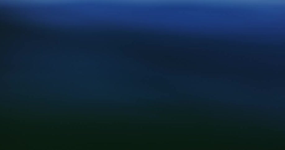The video shows a closeup outoffocus view of deep blue ocean waves rolling under a dim skythe camera moves rhythmically with the water creating a handheld immersive feeling of being adrift at sea