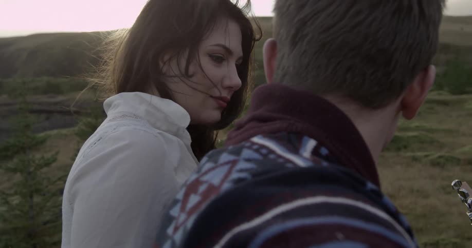A couple sit together on a long green field