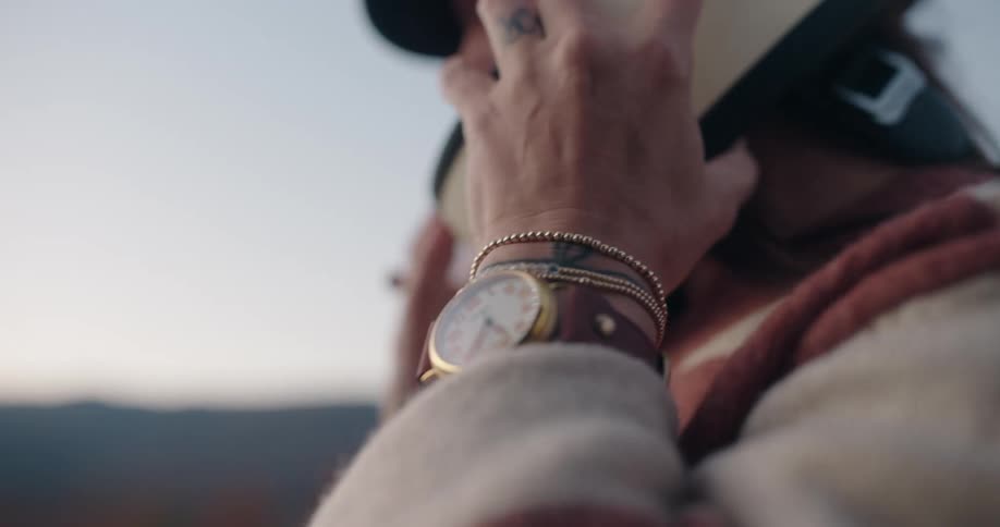 Woman with a watch on her wrist putting on a helmet