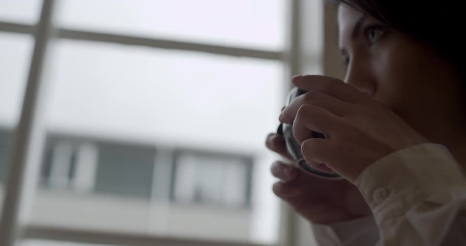 A woman takes a drink from her mug