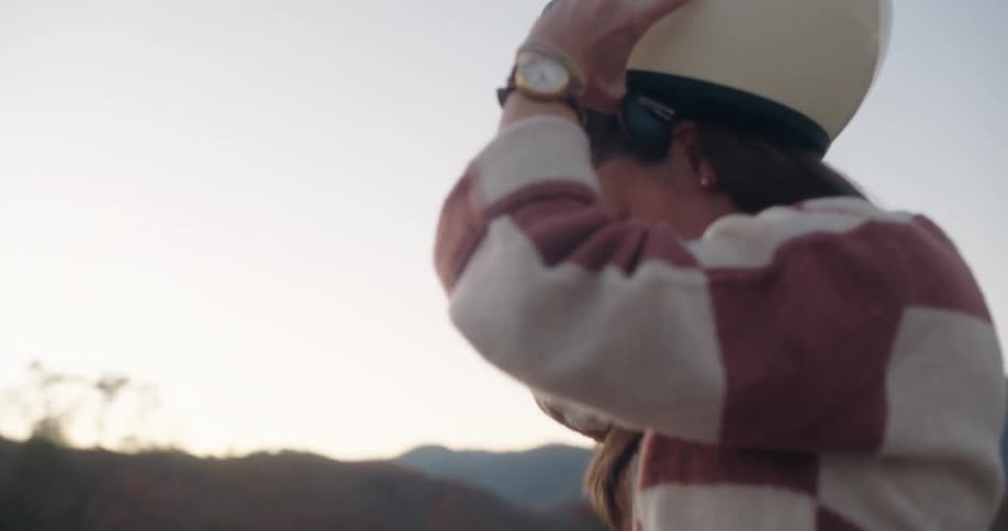 Woman getting off her motorcycle and taking off her helmet