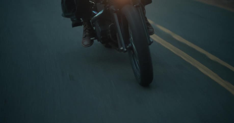 Person riding a motorcycle with the headlight on