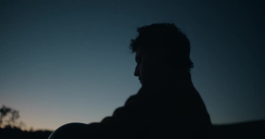 Silhouette of a man putting on a helmet