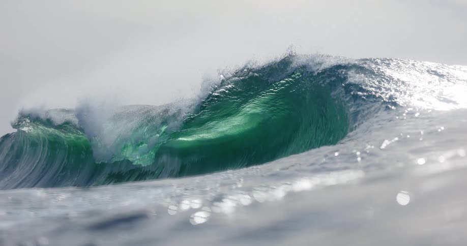Large waves form in the ocean on a sunny day crashing powerfully against the water