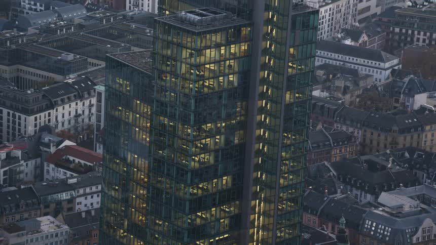 The tall building is lit in the middle of the city