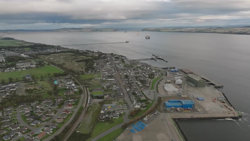 Urban city by the sea with mountains on the horizon