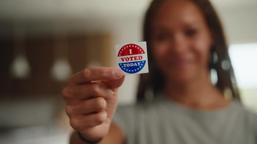 Woman holding a small voting sticker