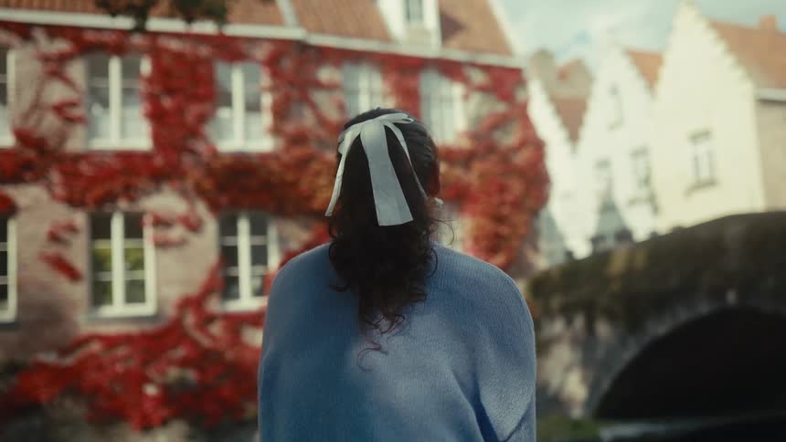 Woman with a bow in her hair enjoying the view of classic houses