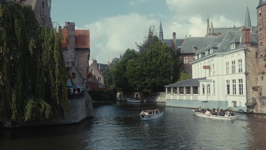Two boats that are floating around in canals in a city