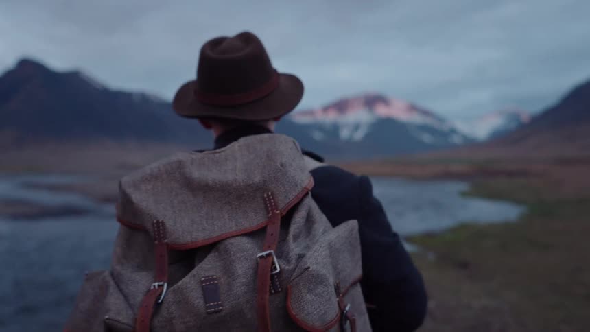 Man hiking along the river in a mountain valley