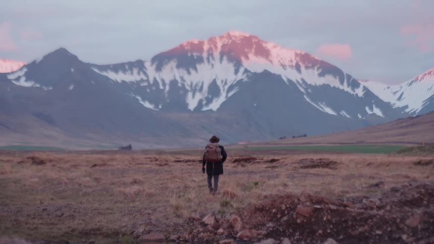 A man hiking outdoors near snowy mountains