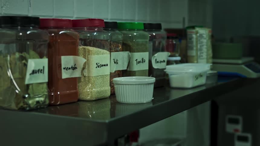 Spices in containers on a table in a restaurant kitchen