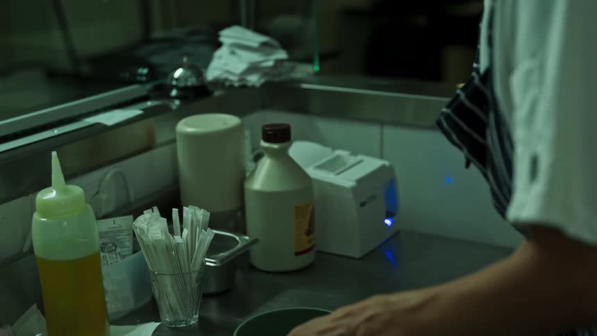 Woman organizes a professional kitchen countertop with containers packaging and utensils