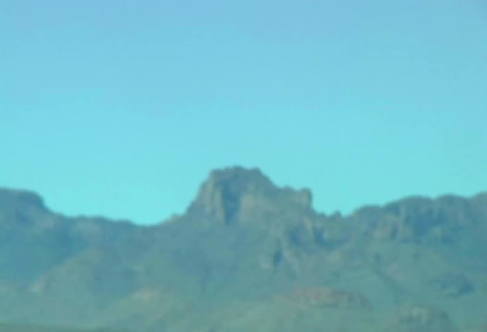 Arid mountain range beneath a blue sky in a wide natural landscape
