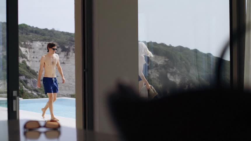 The man and woman walk by their pool