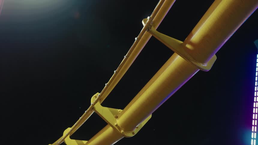 Amusement ride metal structure lit at night with motion captured