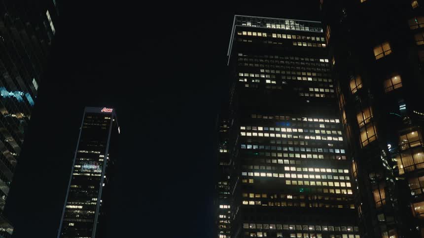 Illuminated office buildings at night in an urban area with lit windows