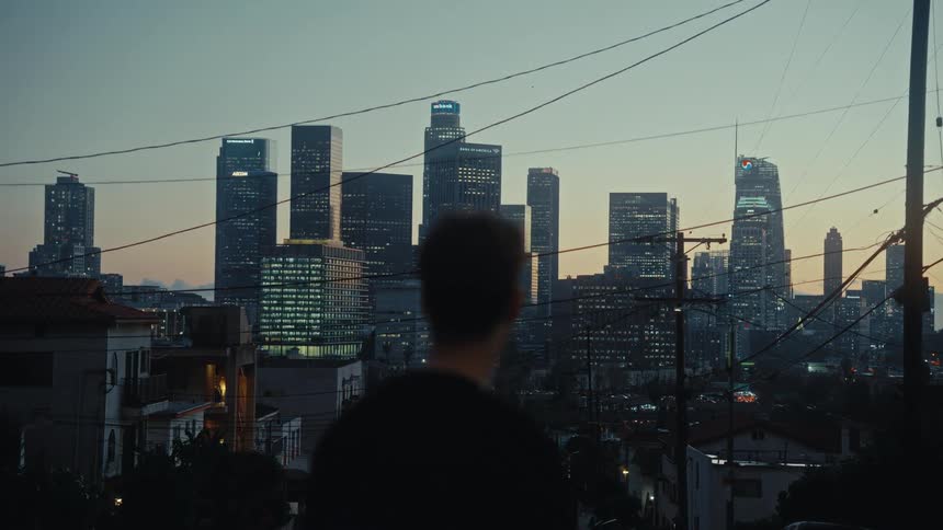 The man looks at the skyline of the large city