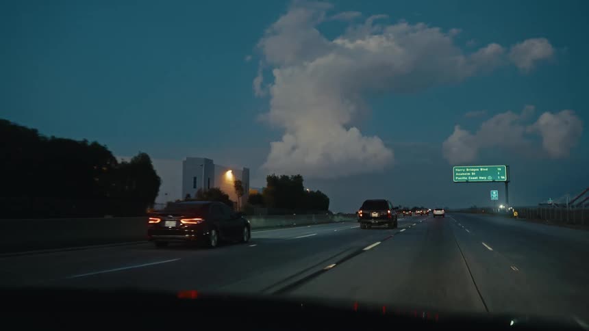 Cars travel on a busy highway at twilight