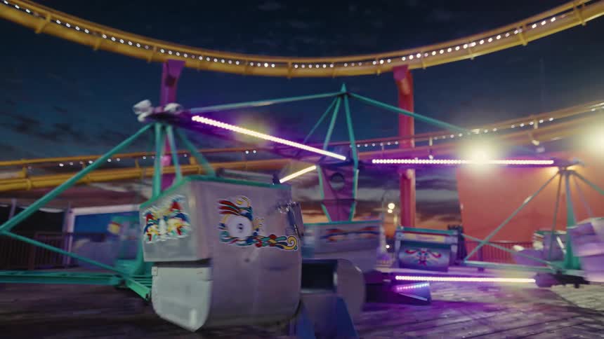 People sit in an amusement park ride as it moves and turns