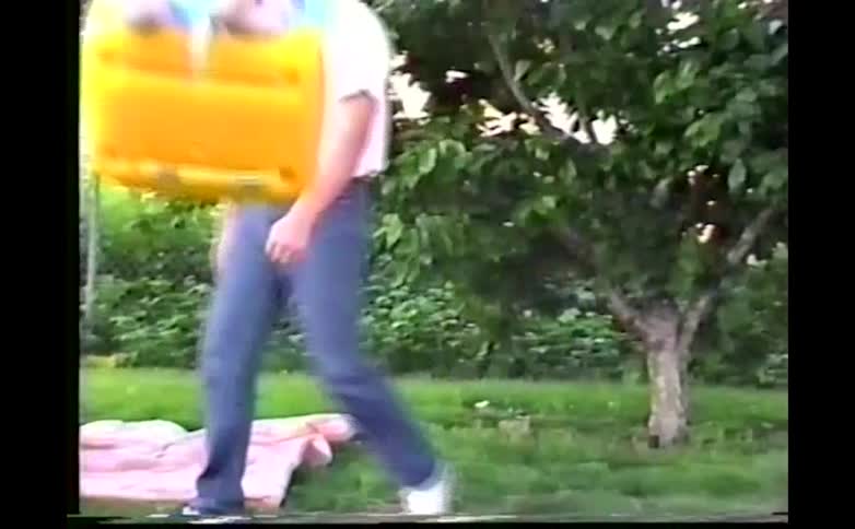 Man pushes his child in a swing then walks around to face the baby on a summer day