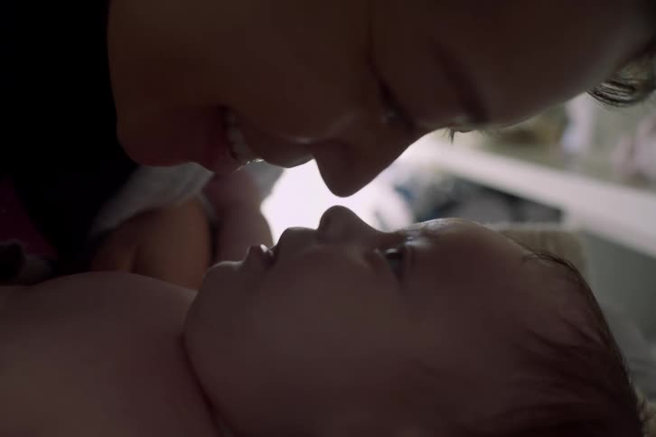 Woman bends down and rubs noses with her baby