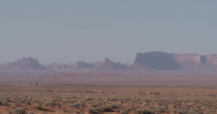 A mountain range in the wilderness at midday overlooking a wide expanse of land
