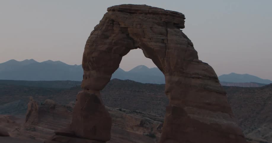 Natural rock arch isolated in a desert landscape with terrain in the background