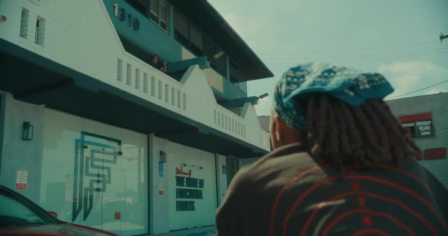 The woman waves to someone on the balcony