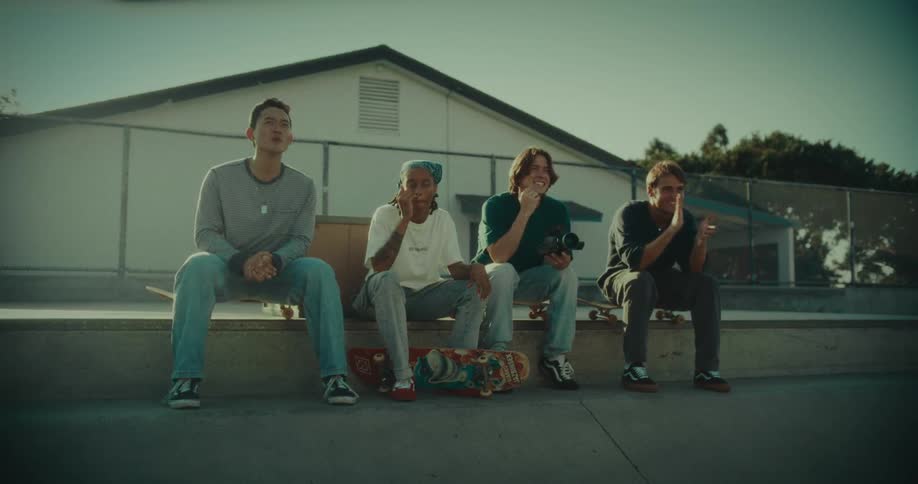 Group of young people sitting with skateboards in an outdoor urban park