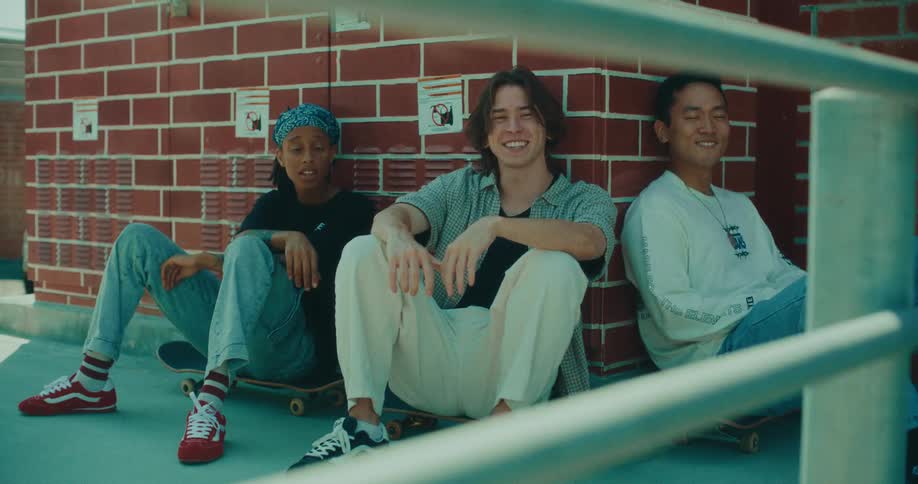 Teenagers sitting on skateboards outside of a building