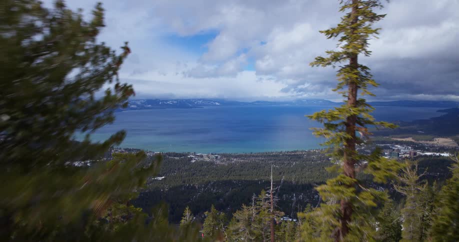 Four friends toast with a drink while standing on a deck in lake tahoe