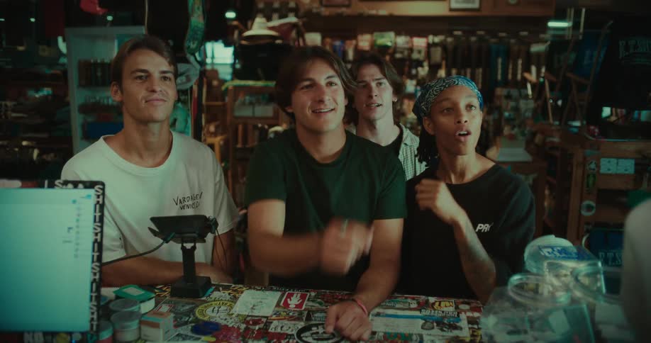 Group of young people examining a skateboard deck in a specialty shop