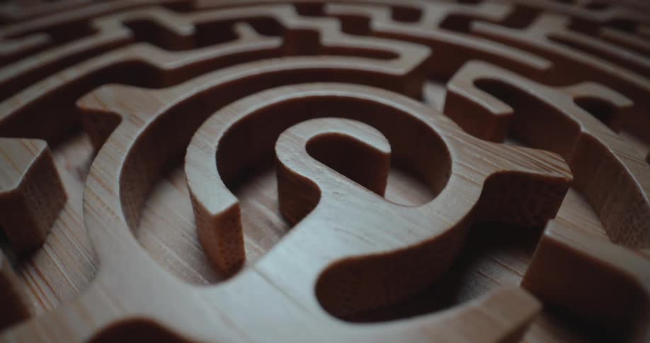 A closeup camera glides over a circular wooden maze revealing deep carved channels and smooth timber grains as it moves across the intricate paths of the labyrinth