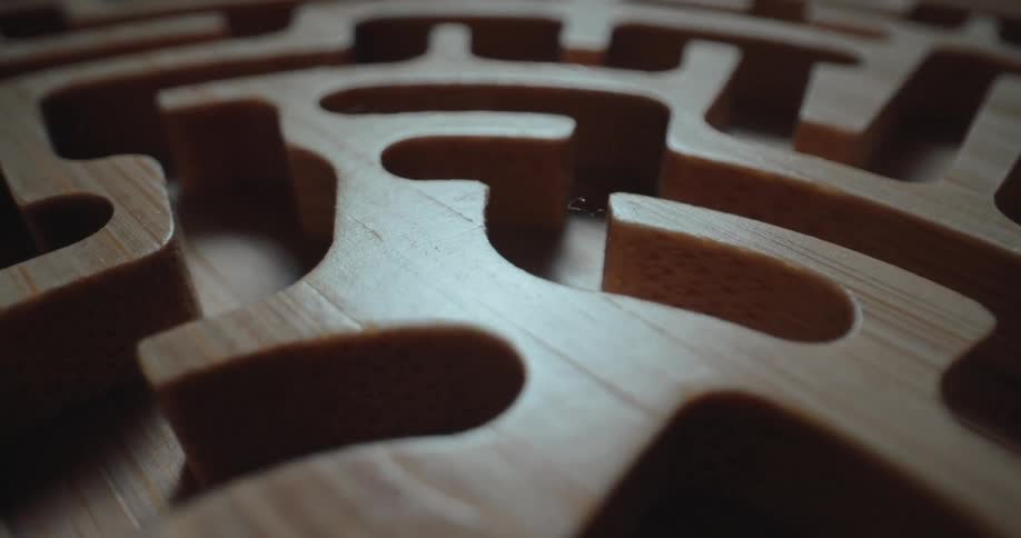 Detail of a wooden maze with carved channels and smooth finish