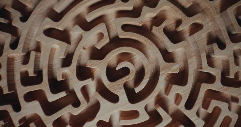 Light shines on a three dimensional labyrinth carved on a round disk as it turns