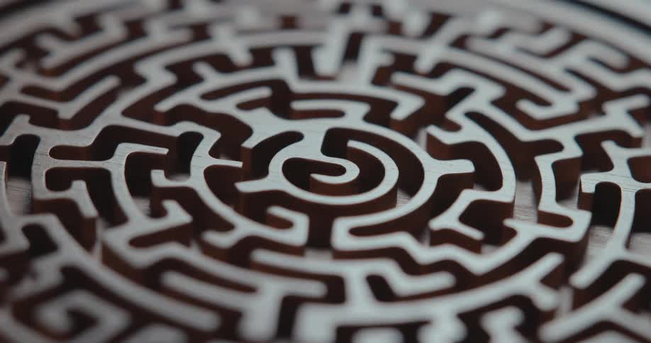 An intricate maze is carved into a circular piece of wood