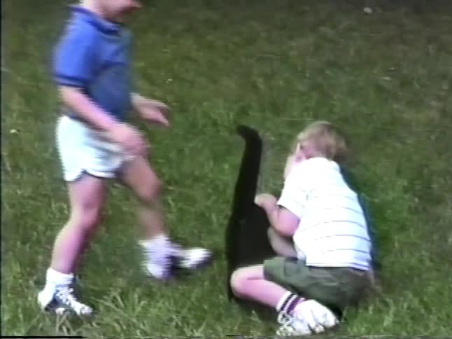 Children sitting on grass interacting during outdoor play