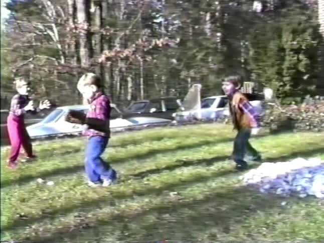 Three little boys playing with a baseball in a neighborhood front yard